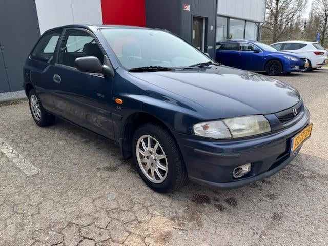 Mazda 323 1.5i P LX (APK tot 1-5-2027!) (bj 1999), Auto's, 1489 cc, Blauw, Origineel Nederlands, Bedrijf