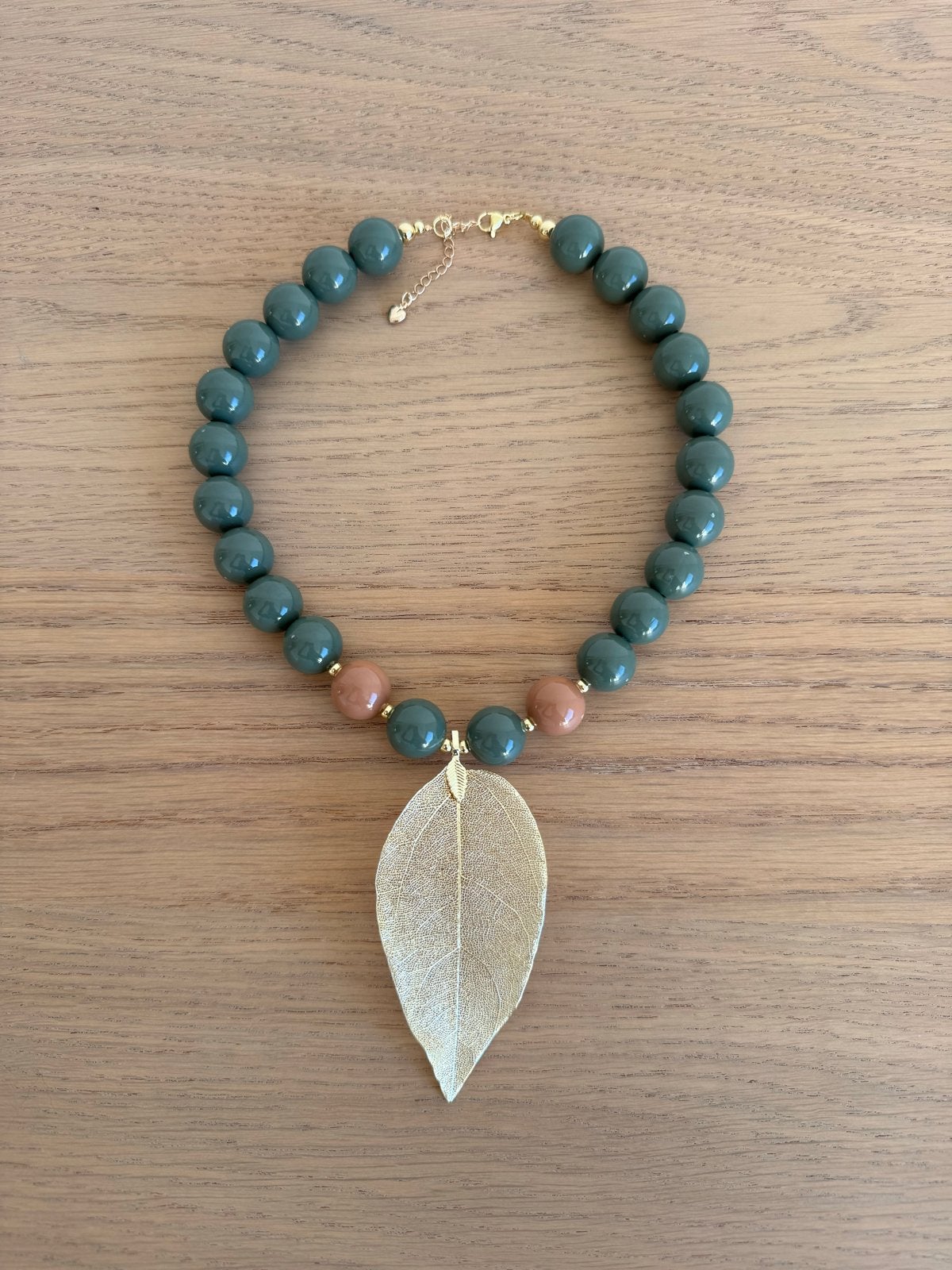 Ketting met groen/bruine kralen en gouden blad hanger, Nieuw, Ophalen of Verzenden, Groen, Overige materialen