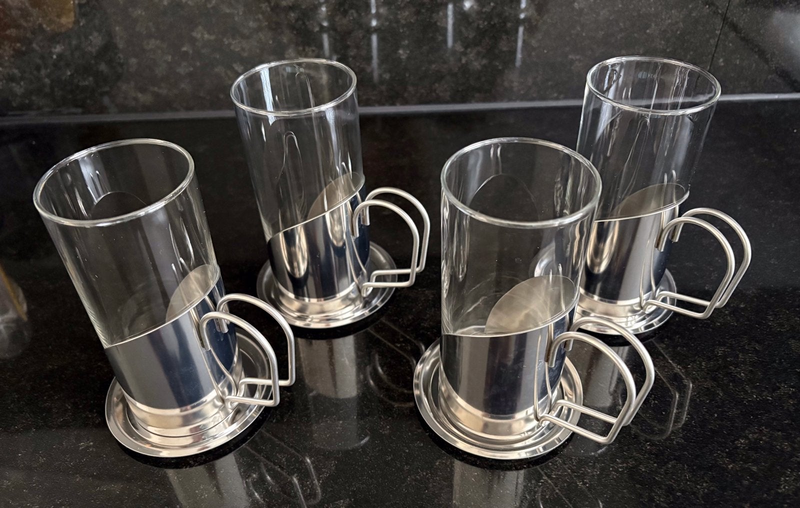 Hittebestendige glazen met RVS-houders en schotels (4 stuks), Glas of Glazen, Overige merken, Ophalen of Verzenden, Overige stijlen