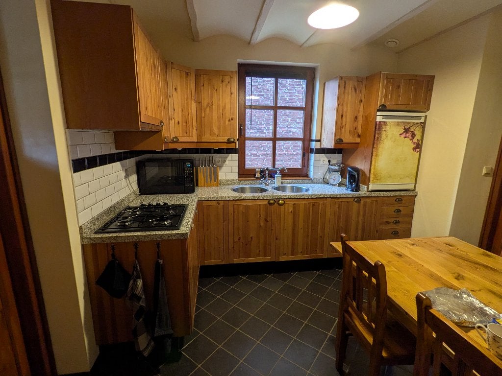 Hoekkeuken met natuurstenen blad en apparatuur