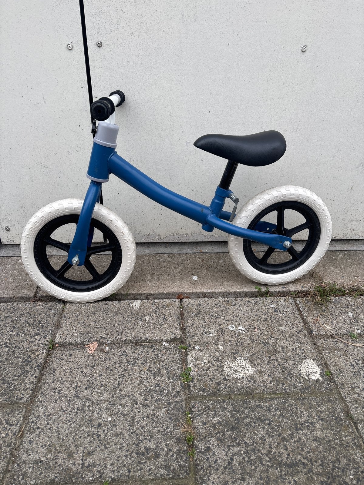 Blauwe loopfiets met witte banden