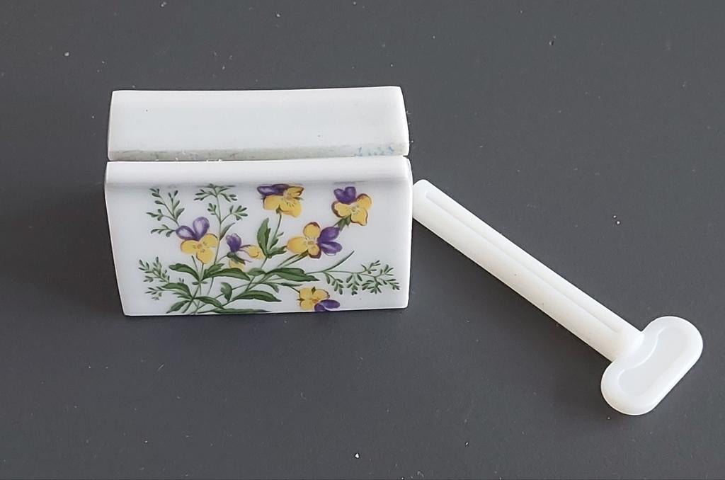 Een keramieken tube-uitknijper met een bloemendecor., Ophalen of Verzenden