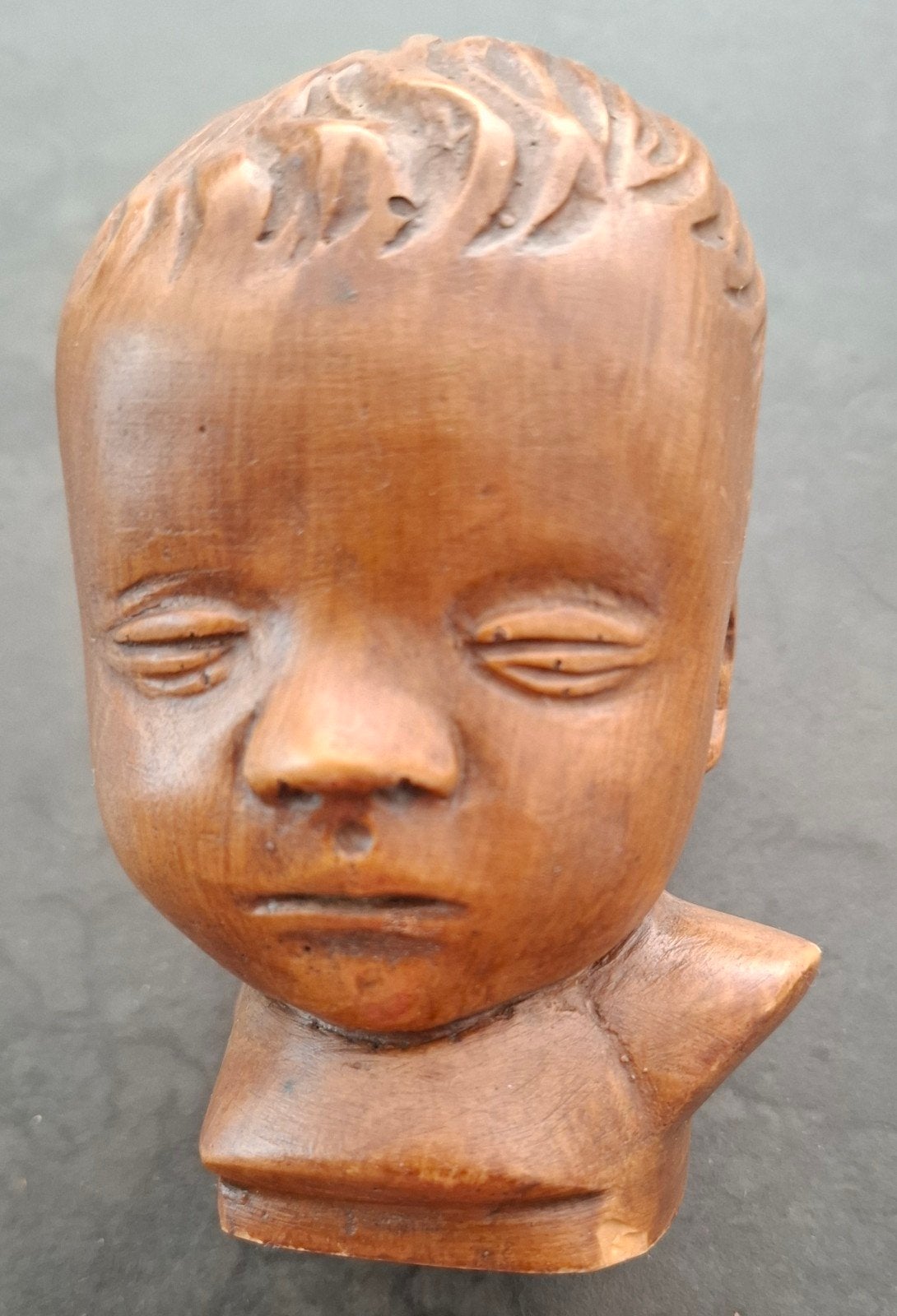 Stenen kinderkopje. Kleur bruin.  Hoog 12cm breed 11cm, Ophalen