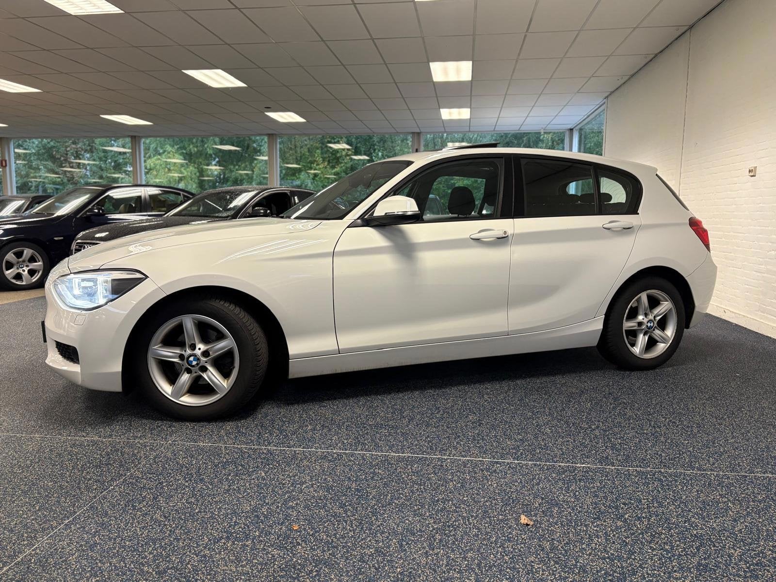 BMW 1-serie 118d Business+ | Automaat | Pano | Navi | Cruise, Auto's, Euro 5, Achterwielaandrijving, Wit, 140 €/maand