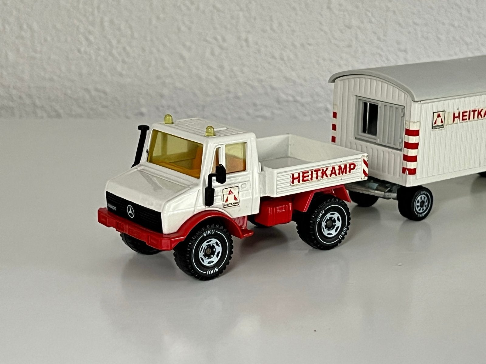 Siku 2519 Mercedes Unimog met bouwkeet 'Heitkamp' nieuwstaat, Hobby en Vrije tijd, Modelauto's | 1:50, Ophalen of Verzenden, Zo goed als nieuw