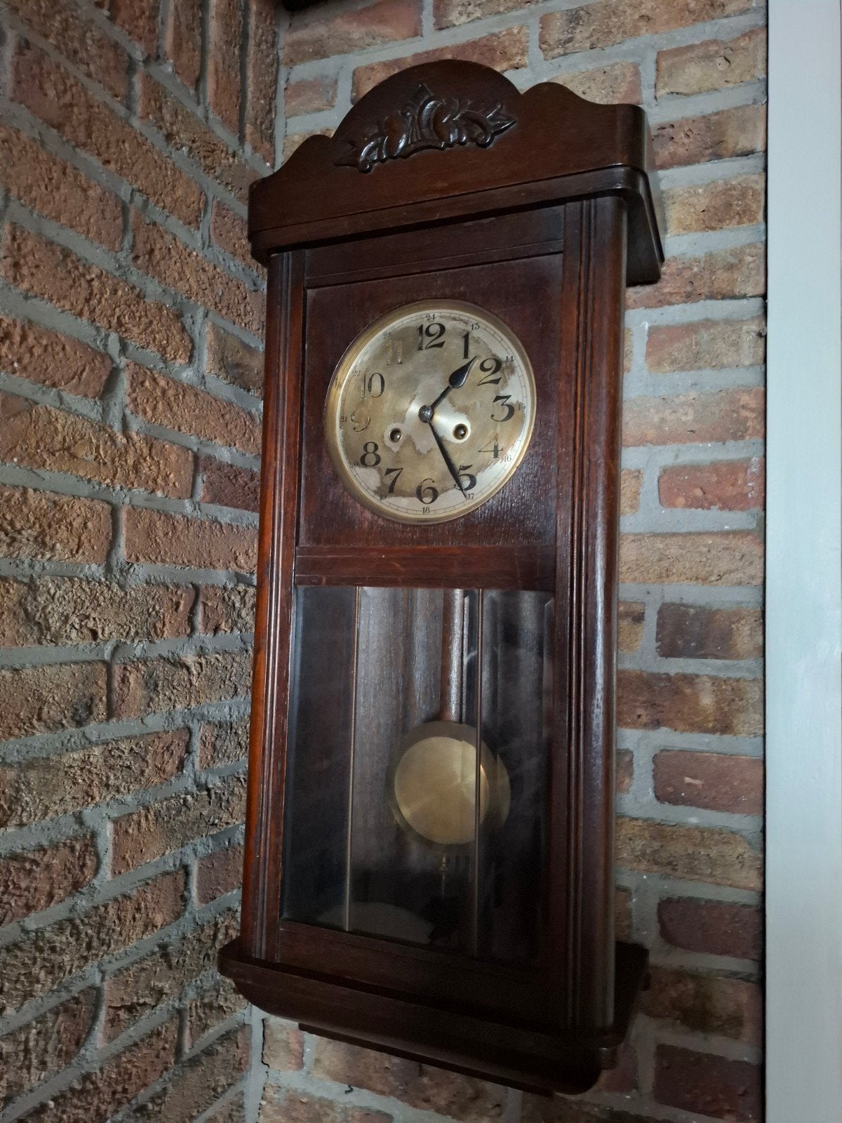 Oude wandklok met slinger en sleutel, Ophalen