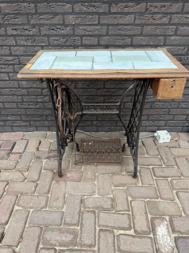 Antieke naaimachine met onderstel, Ophalen