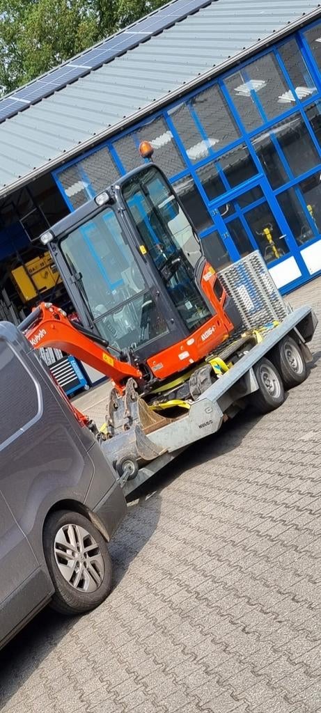 Minigraver met machinist en bestratingen