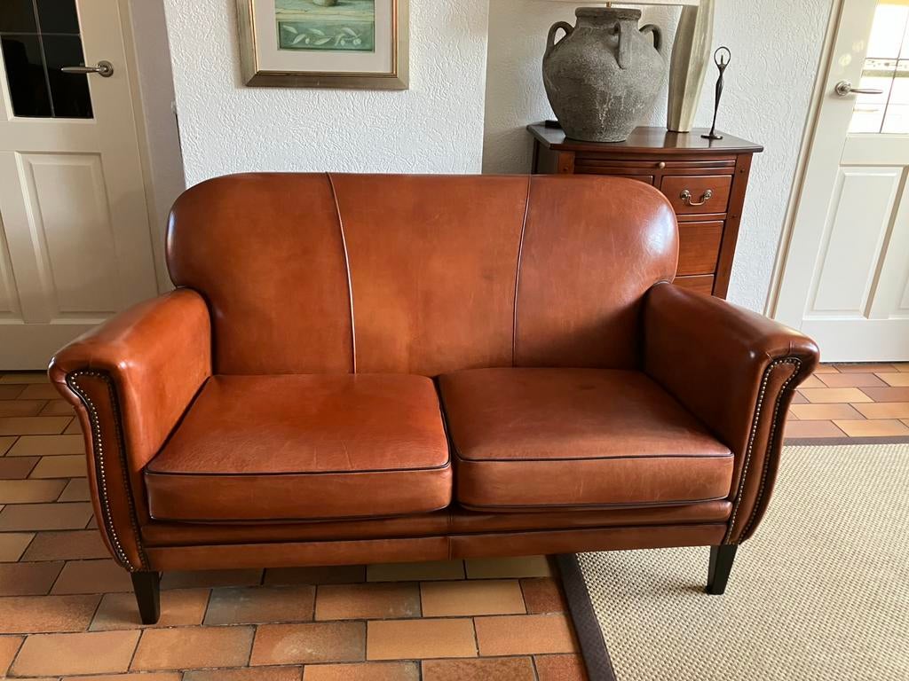 Schapenleren(cognac) 2 zitsbank genageld zwarte bies izgs, Ophalen, 50 tot 75 cm, Zo goed als nieuw, Schapenleer 2 zitsbank landelijk vintage mancave
