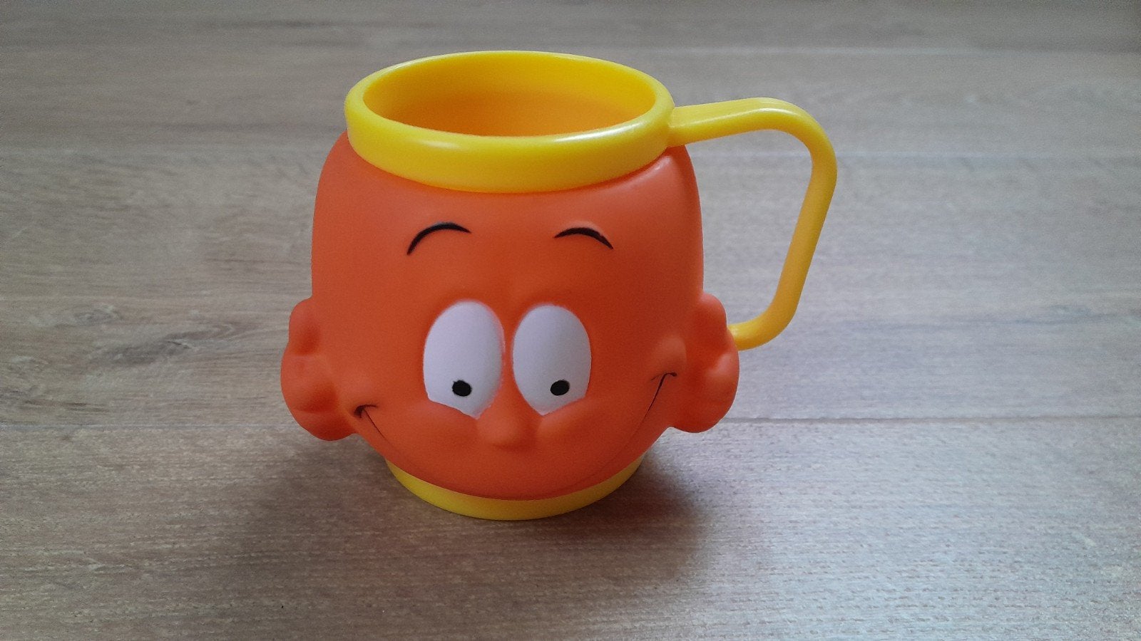 Leuke oranje kinderbeker met gezichtje, Ophalen of Verzenden, Zo goed als nieuw
