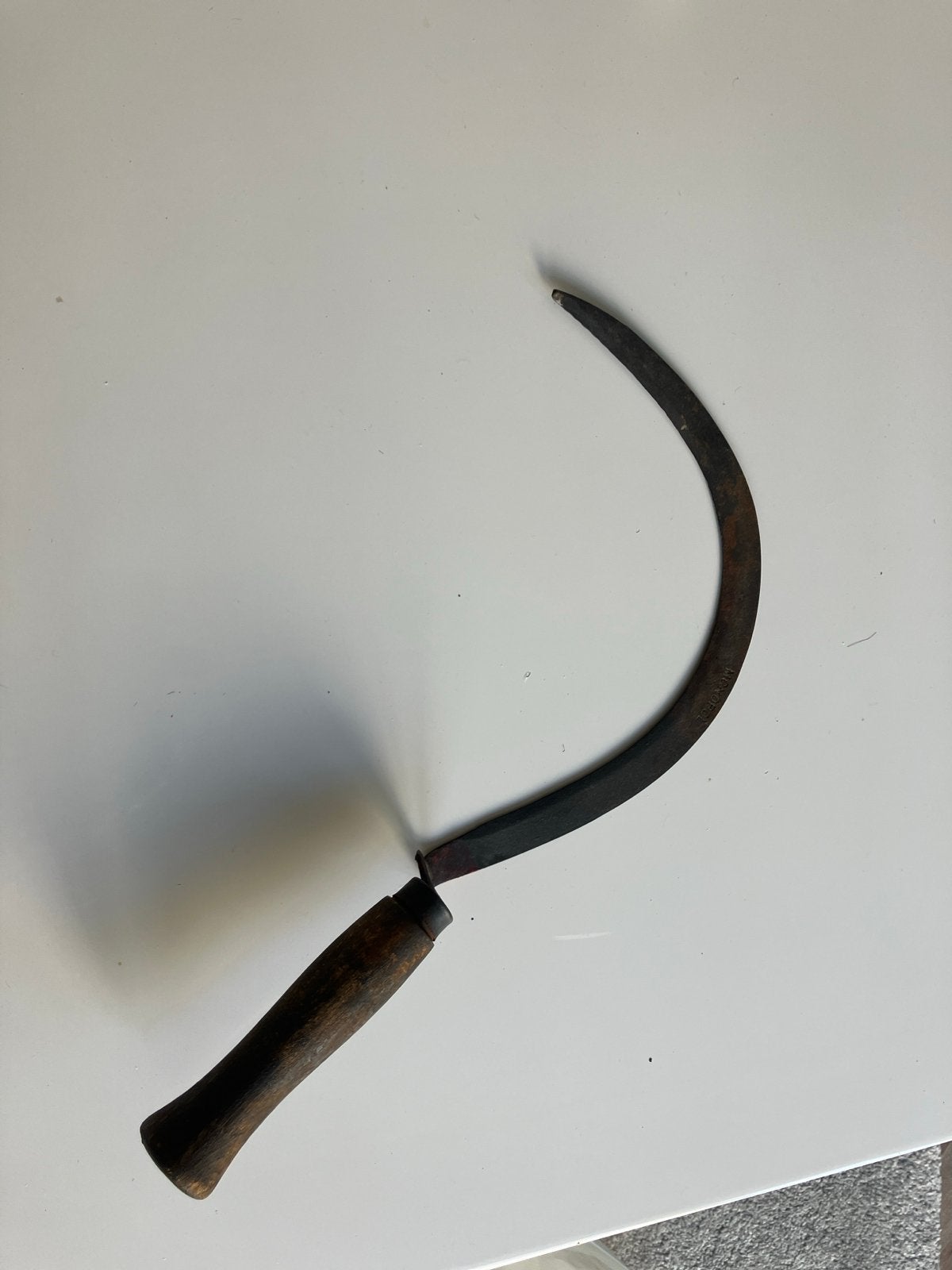 Antieke sikkel met houten handvat, Ophalen