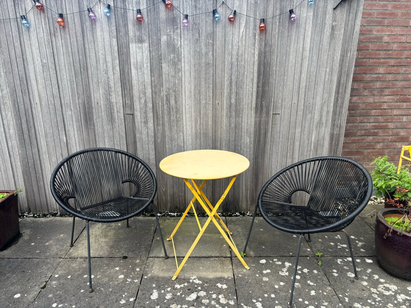 Gezellige tuinset: 2 zwarte stoelen en gele tafel
