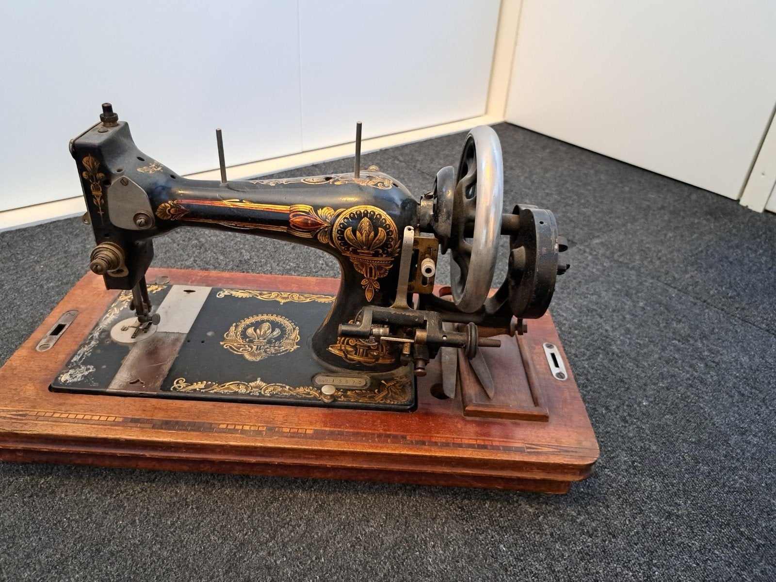Antieke naaimachine met houten onderstel, Ophalen