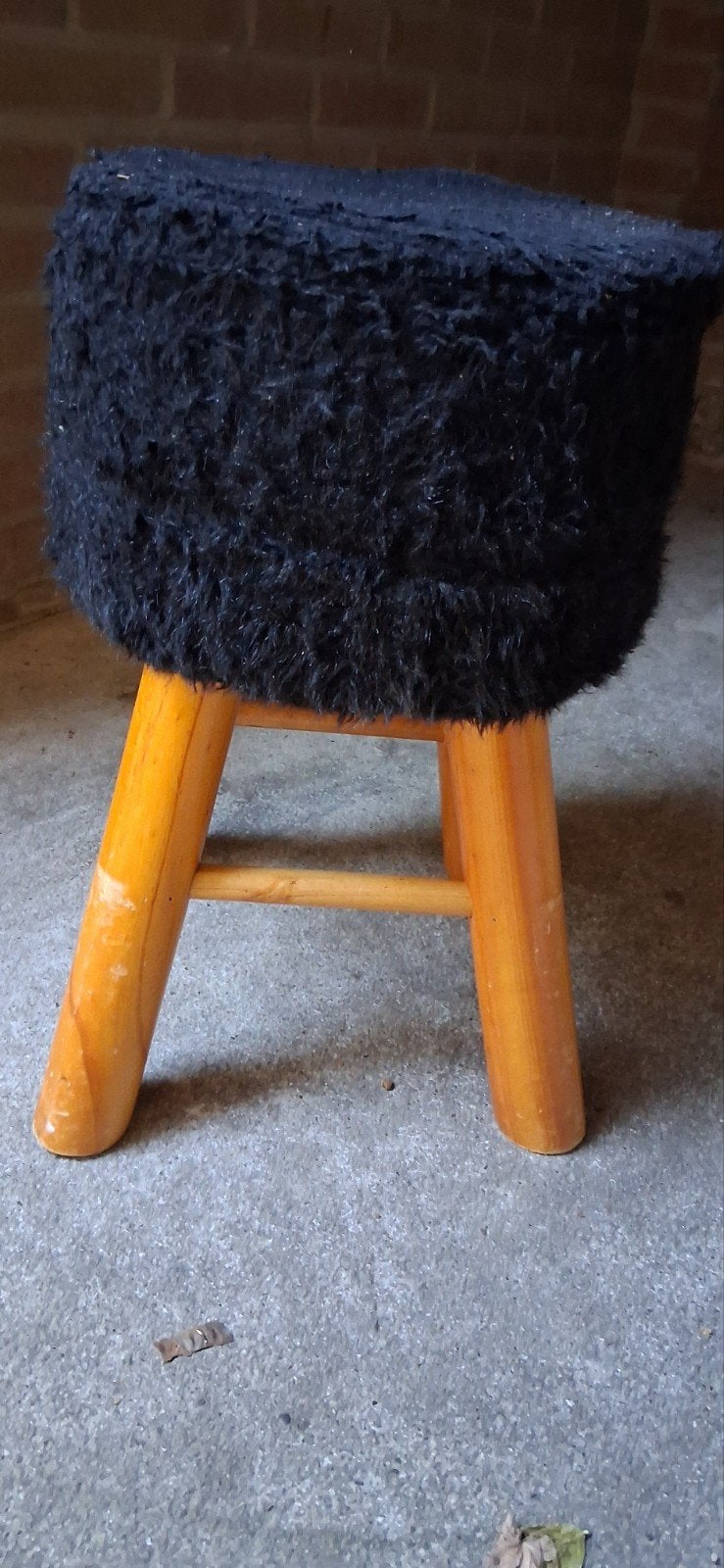 Zwart pluizig krukje met houten poten, Ophalen