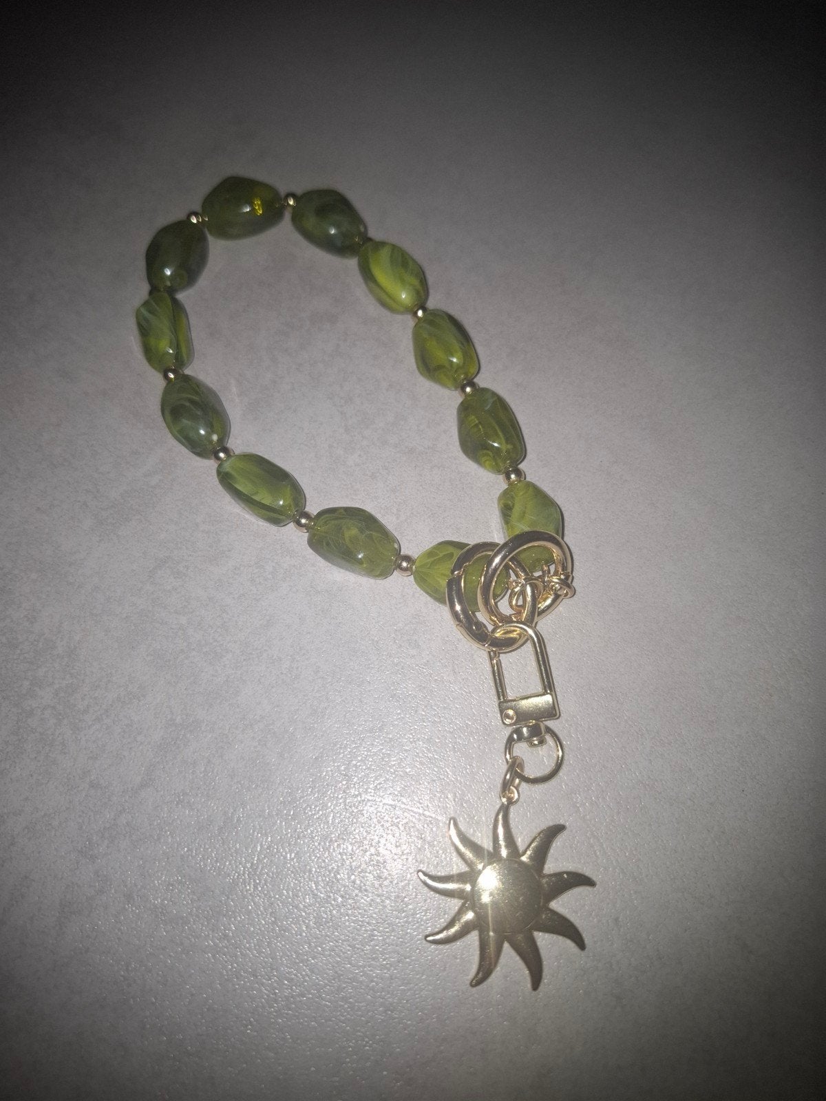 Groene kralen telefoonarmband met goudkleurige zon, Ophalen of Verzenden, Zo goed als nieuw, Overige typen
