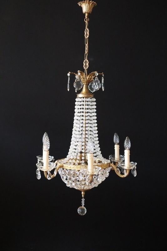 Bronzen kroonluchter met binnenin lampen rondom kaarslampen
