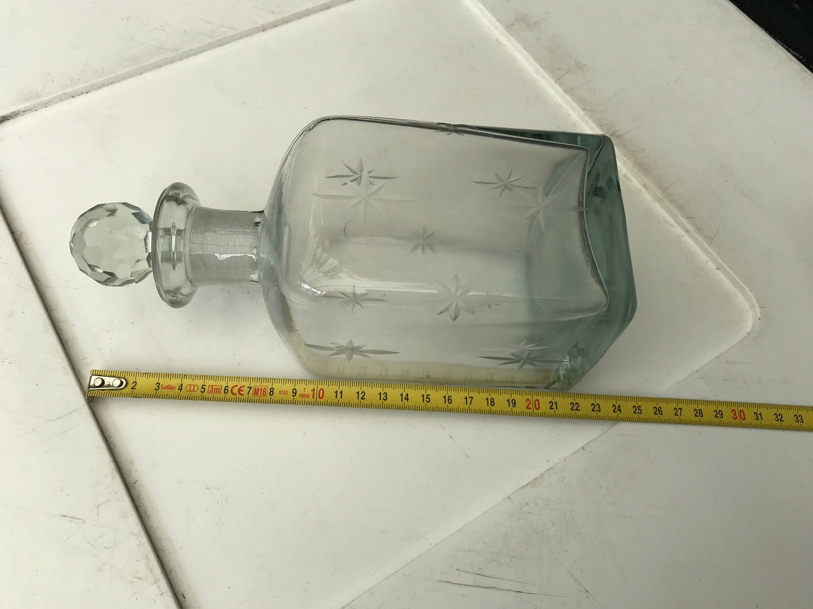 Oude geslepen glazen karaf met stop, Ophalen