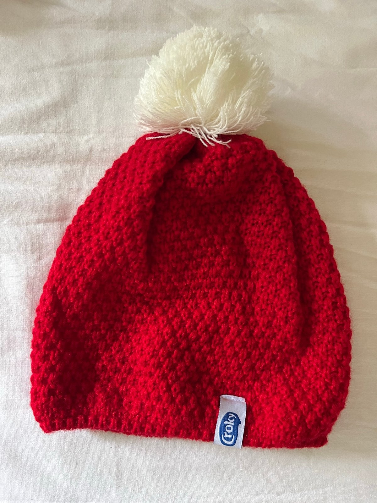 Warme rode muts met witte pompon - Croky, Ophalen of Verzenden, Zo goed als nieuw, Muts