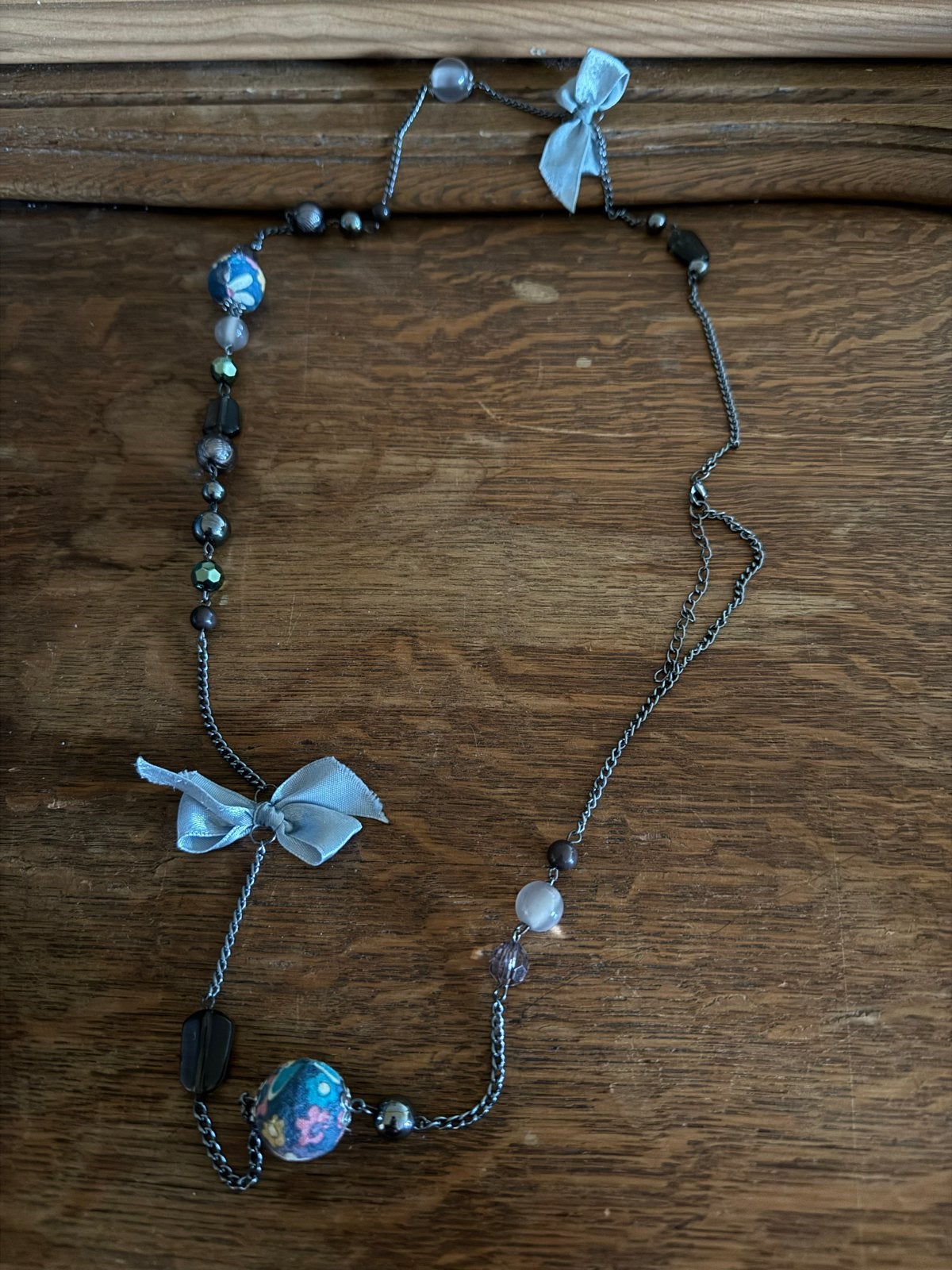 Lange ketting met kralen en strikjes, Sieraden, Tassen en Uiterlijk, Kettingen, Ophalen of Verzenden, Zo goed als nieuw, Grijs