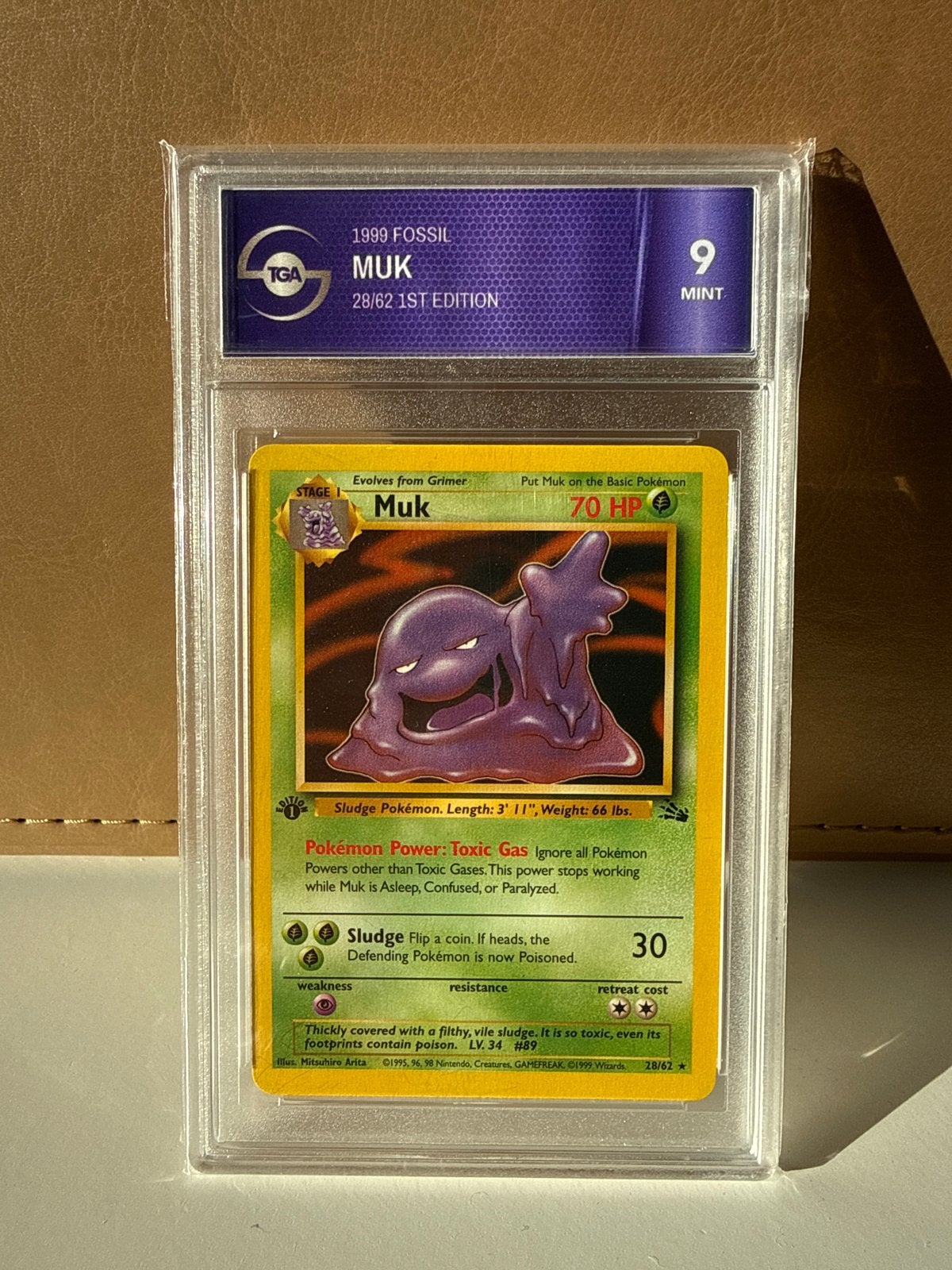 Pokémon Muk 1999 Fossil 1st Edition TGA 9 Mint, Ophalen of Verzenden, Zo goed als nieuw, Losse kaart
