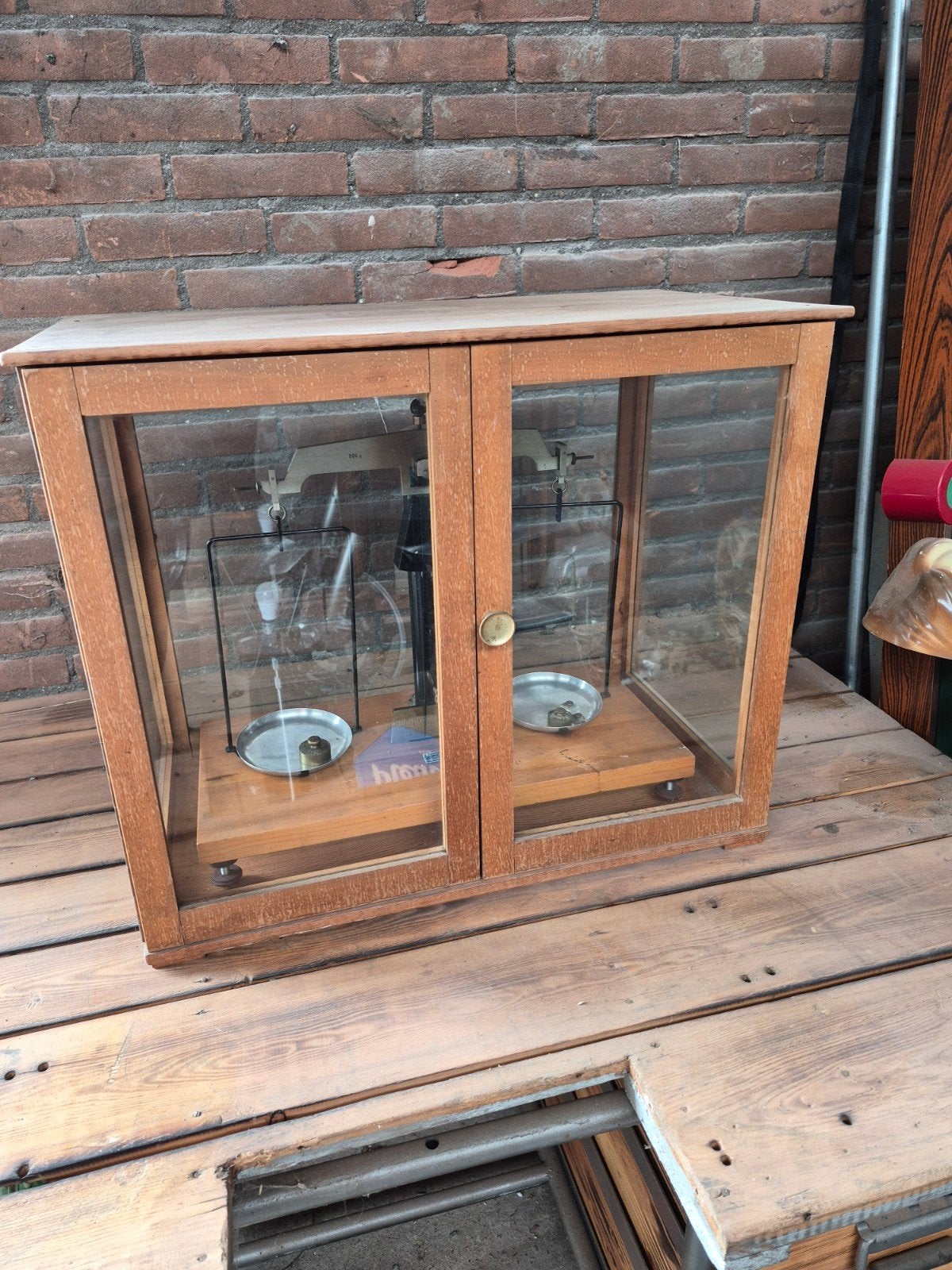 Antieke balansweegschaal in vitrinekast, Ophalen
