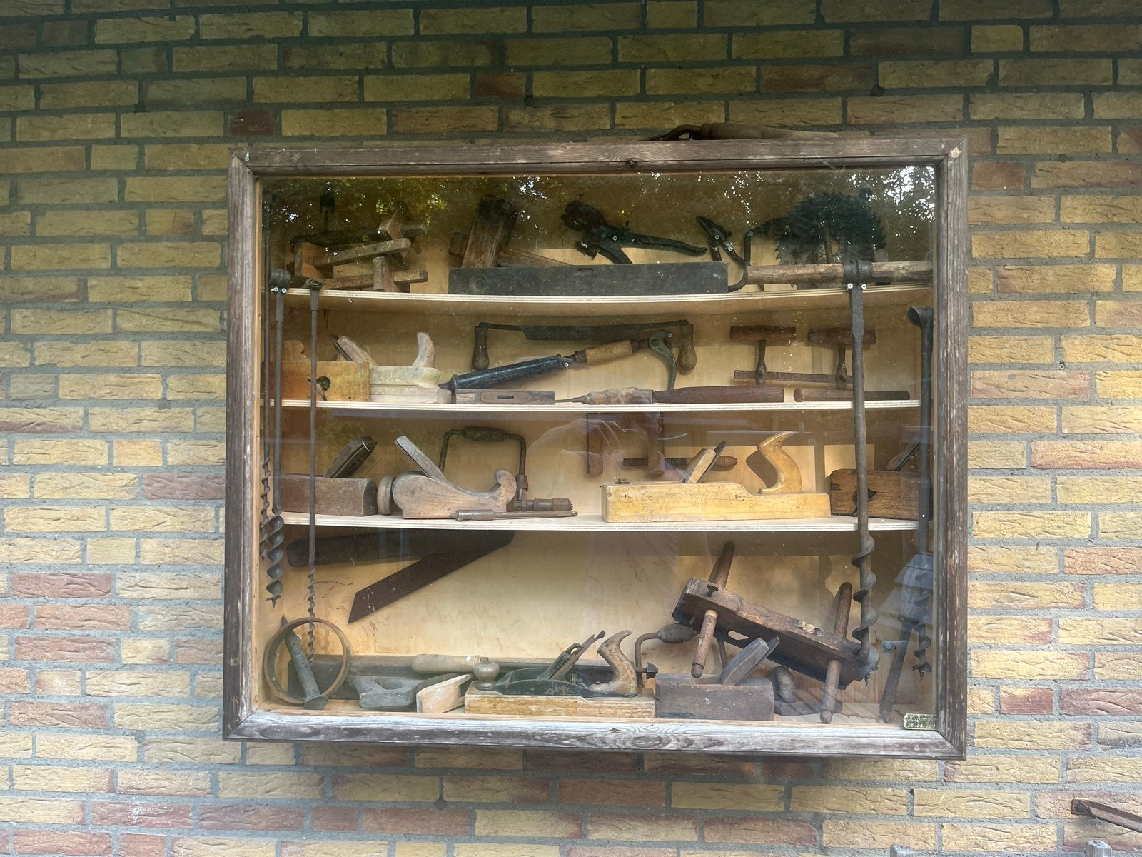 Antieke timmermansgereedschappen in vitrine, Ophalen