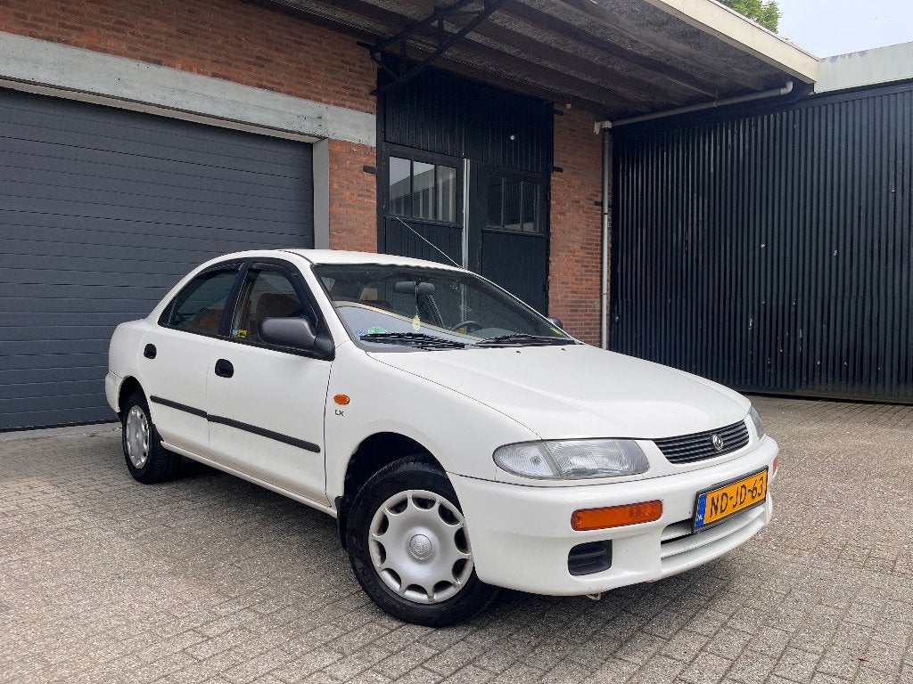 Mazda 323 1.5 I SDN LX AUT 2 JAAR APK, Auto's, Automaat, Stof, 1489 cc, 400 kg