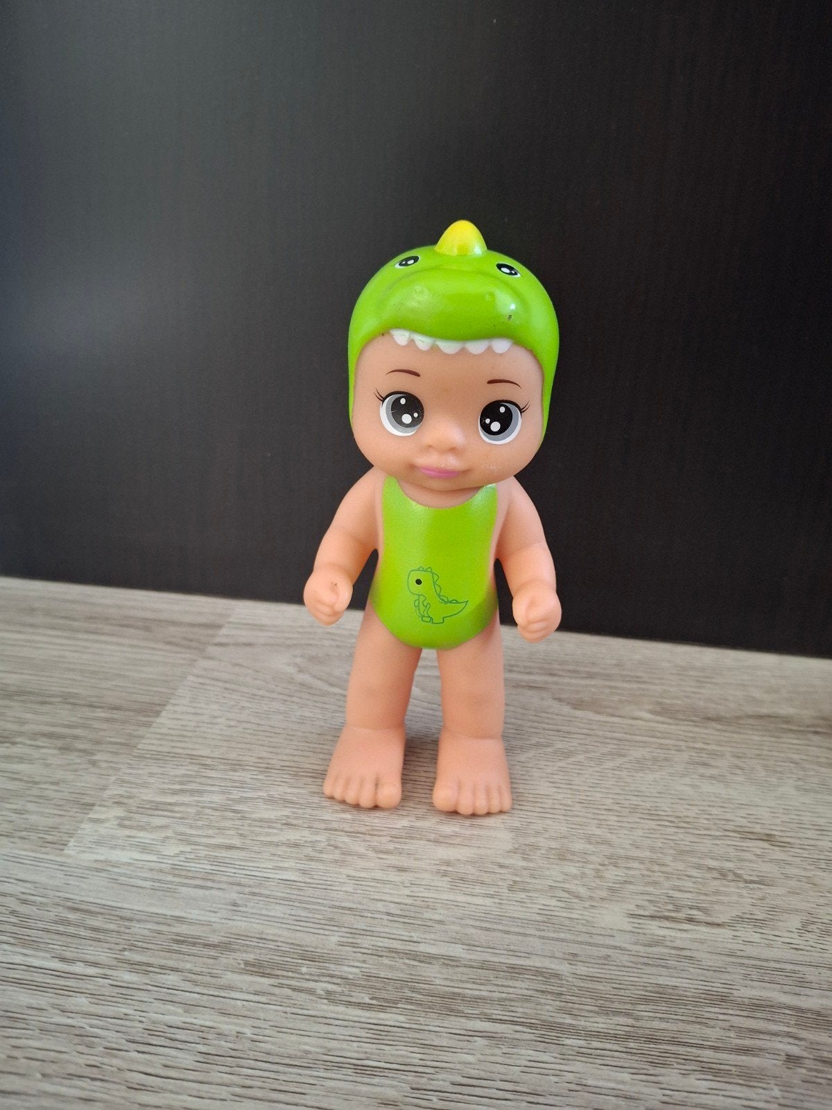 Leuke babypop in groen dinopakje van Action, Ophalen of Verzenden, Zo goed als nieuw, Babypop