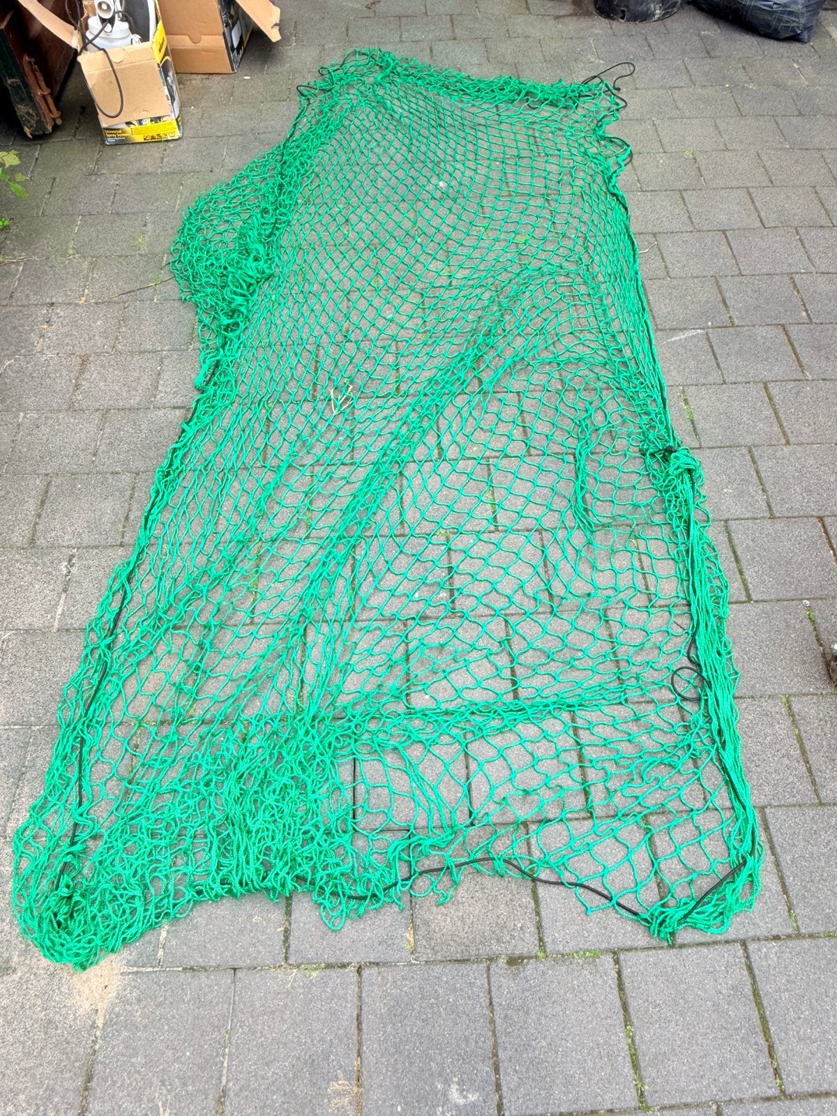 • Een stevig groen afdeknet voor een aanhangwagen., Ophalen