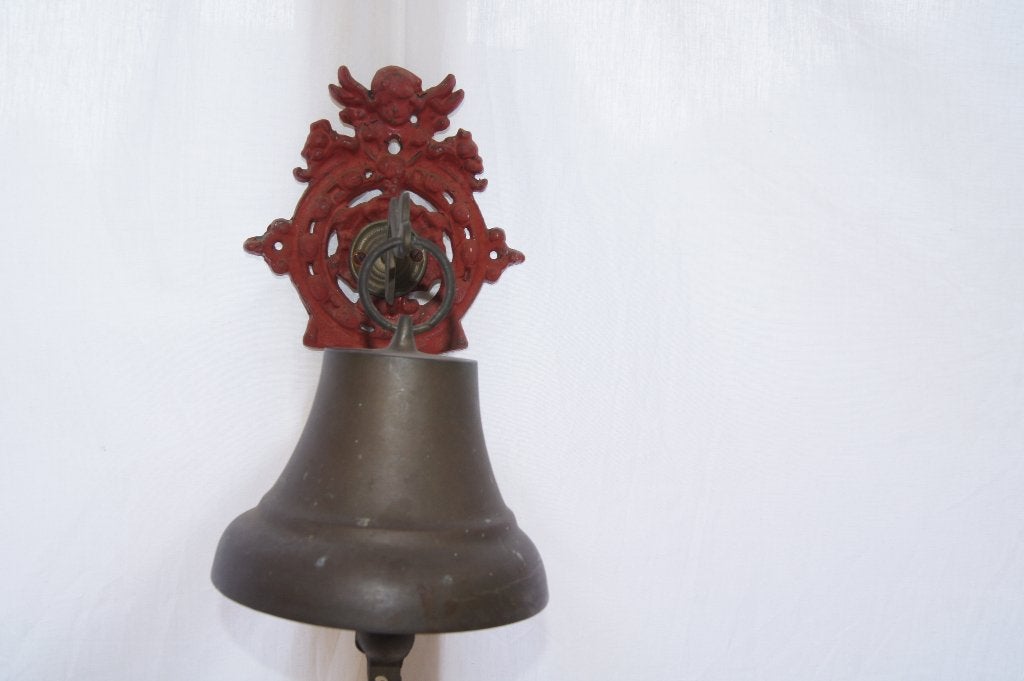Bronzen bel aan  rood gietijzeren ornament., Antiek en Kunst, Ophalen of Verzenden