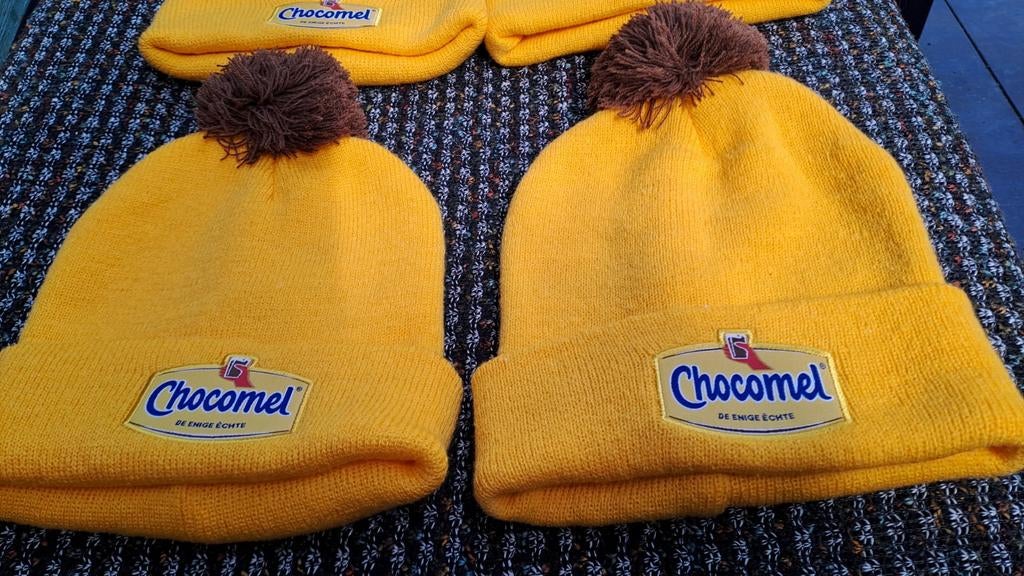 Chocomel Muts - Geel met Bruine Pompon, Verzamelen, Merken en Reclamevoorwerpen, Gebruiksvoorwerp, Nieuw, Ophalen of Verzenden