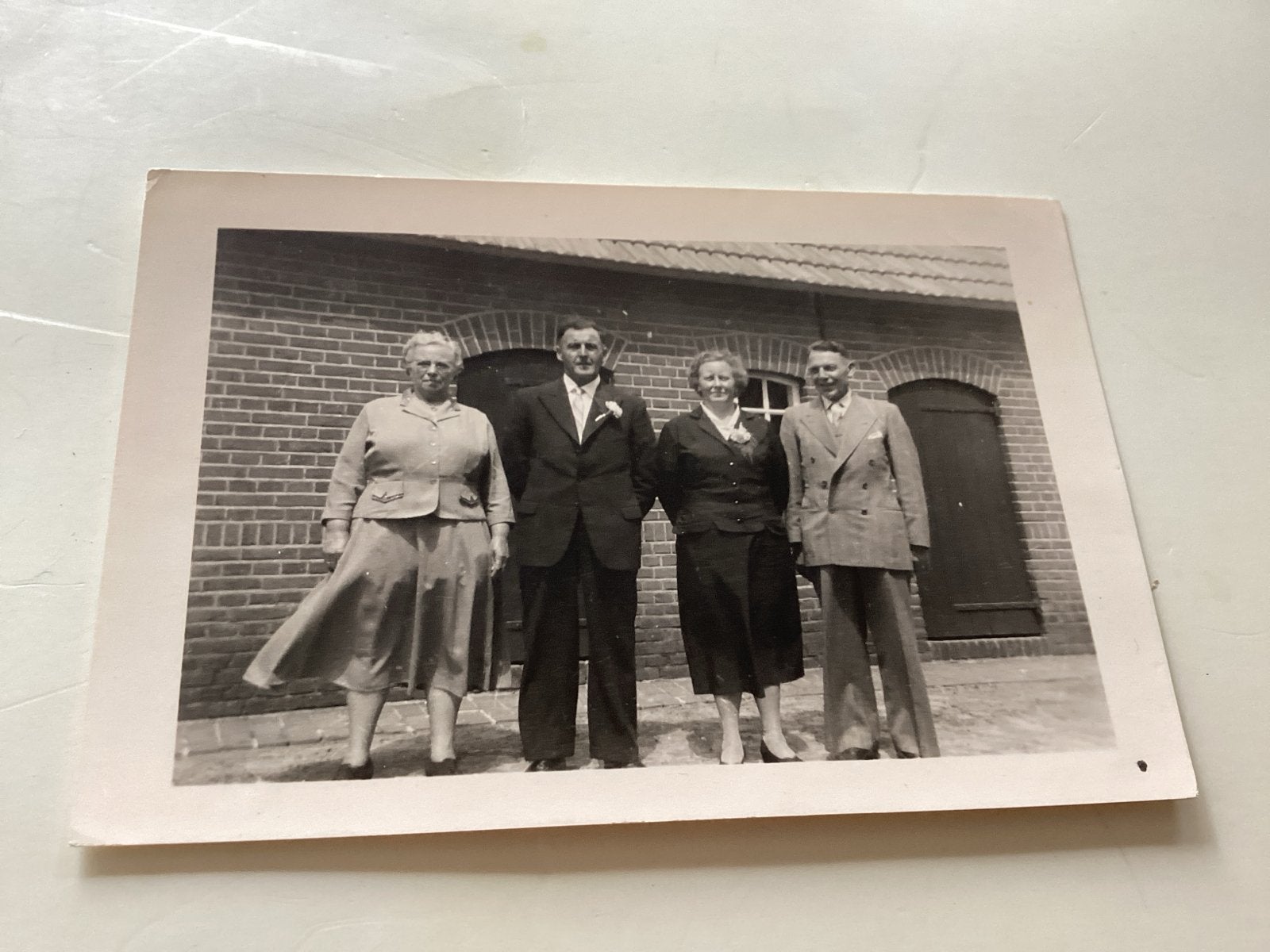 Vier personen voor bakstenen gebouw 6x9 cm, Verzamelen, Gebruikt, Foto, Ophalen of Verzenden, 1940 tot 1960