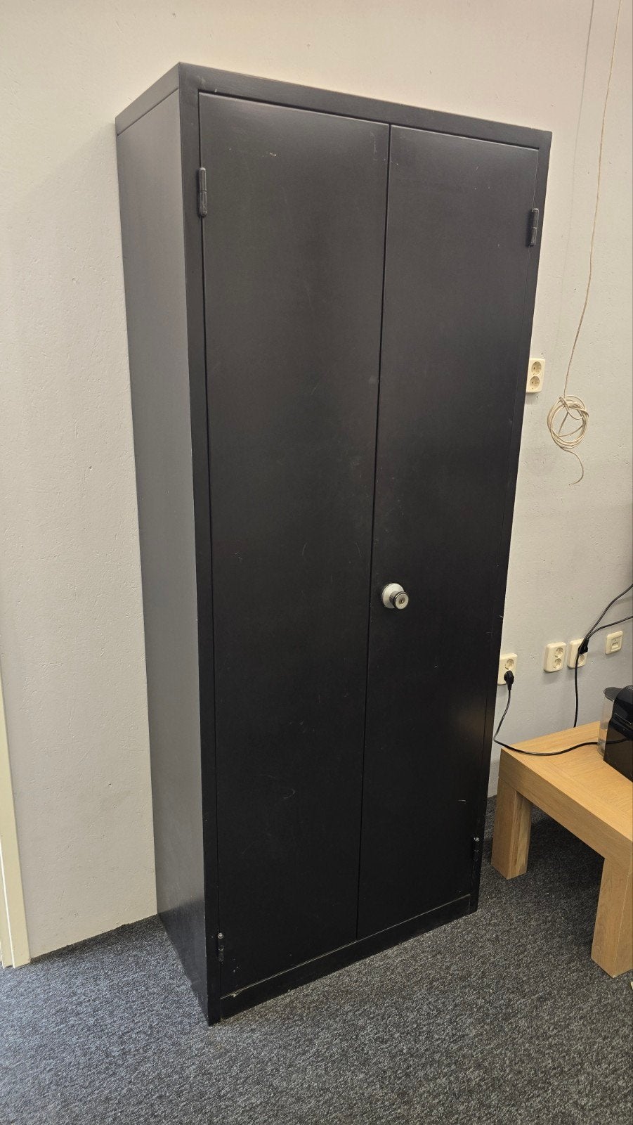 Zwarte metalen kast met twee deuren en planken