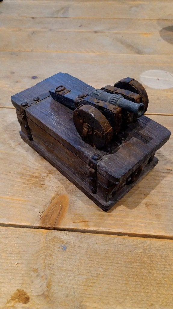 miniatuurkanon op een houten kistje, Ophalen