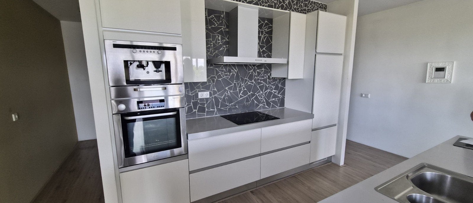 Moderne witte keuken met kookeiland en inbouwapparatuur, Ophalen