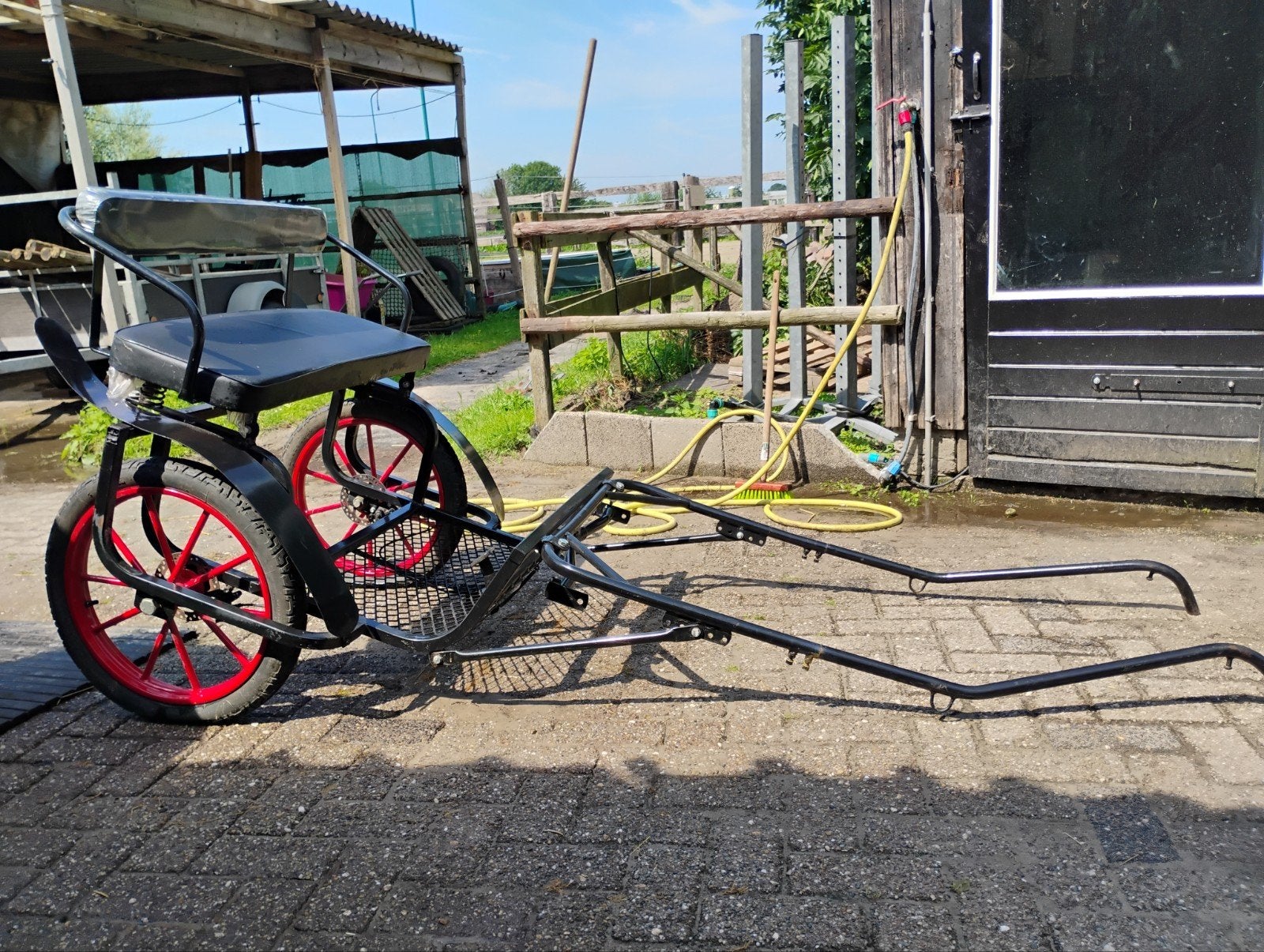 Sulky cavalettie met rode wielen, spatborden en beschermhoes