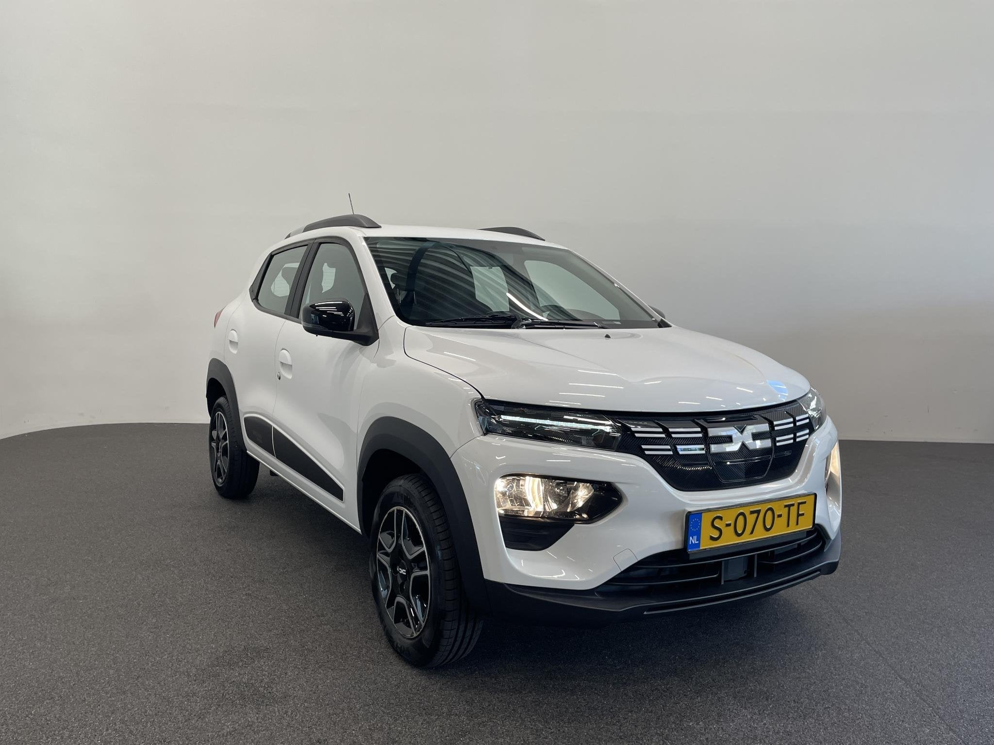 Dacia Spring Essential 27 kWh Airco, Auto's, Gebruikt, Zwart, Leder en Stof, Wit