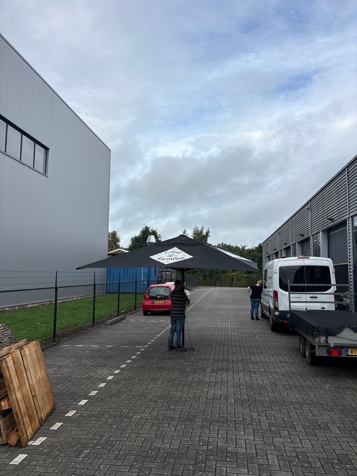 Grote zwarte parasol met Tripel Karmeliet logo