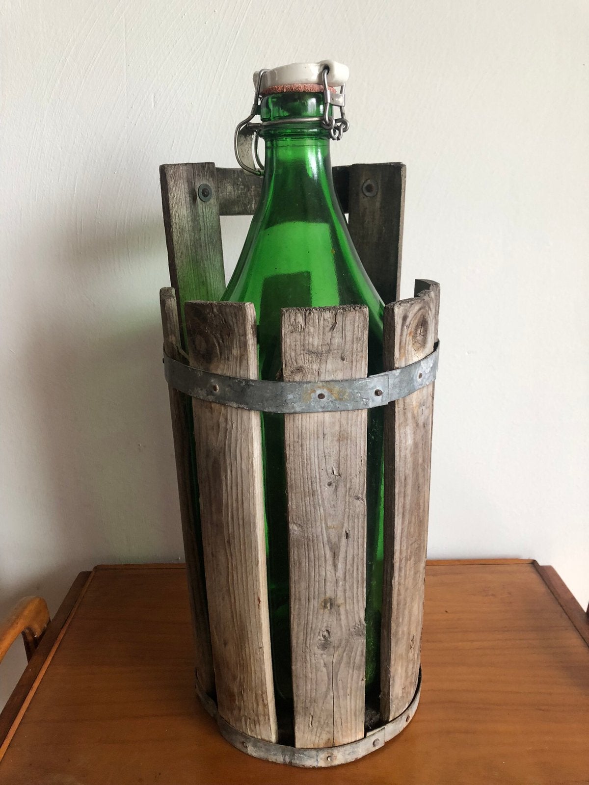 Grote groene wijnfles in houten hiuder., Ophalen of Verzenden
