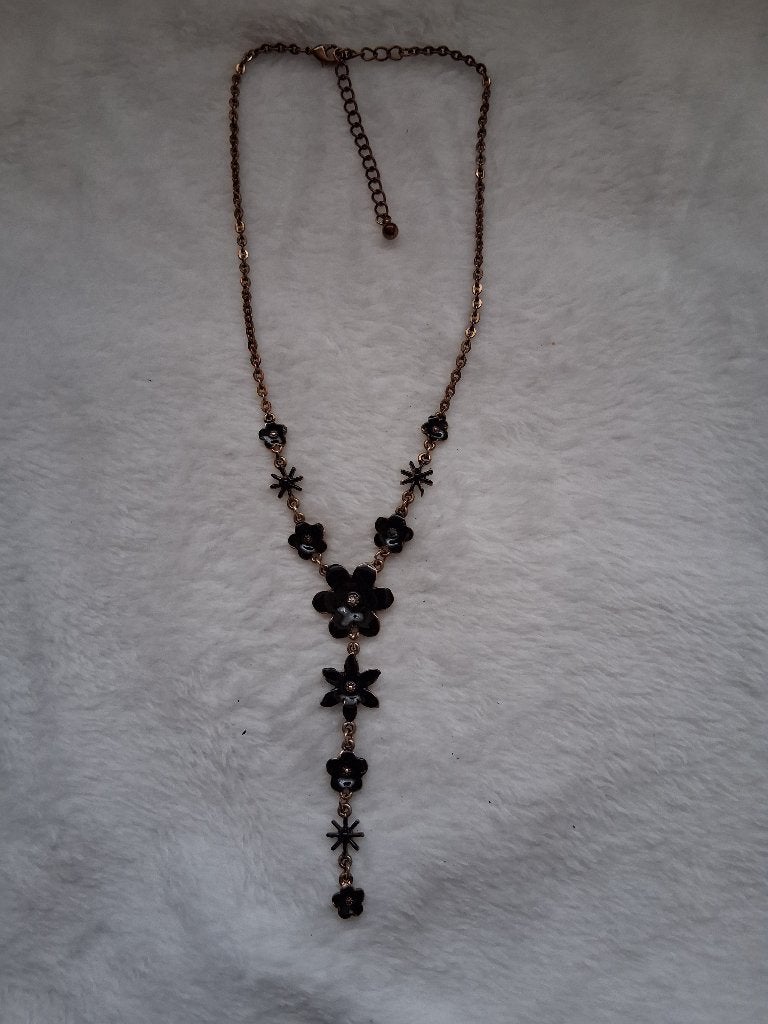 Een goud kleurige ketting met zwarte bloemmetjes., Overige materialen, Ophalen of Verzenden, Goud, Verstelbaar