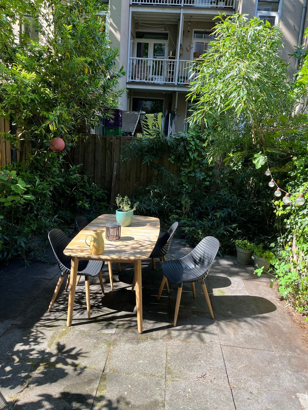 Stijlvolle tuinset met houten tafel en 4 zwarte stoelen