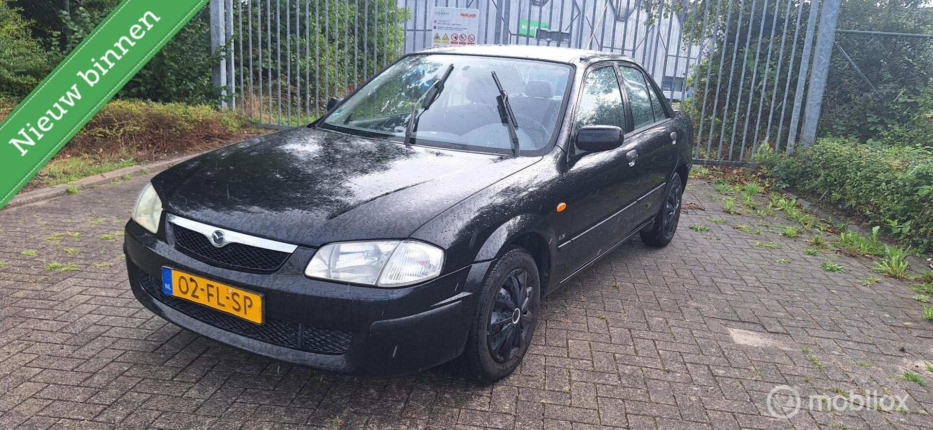 Mazda 323 1.5i LX nieuwe A.P.K, Auto's, Stof, 4 cilinders, 400 kg, Zwart