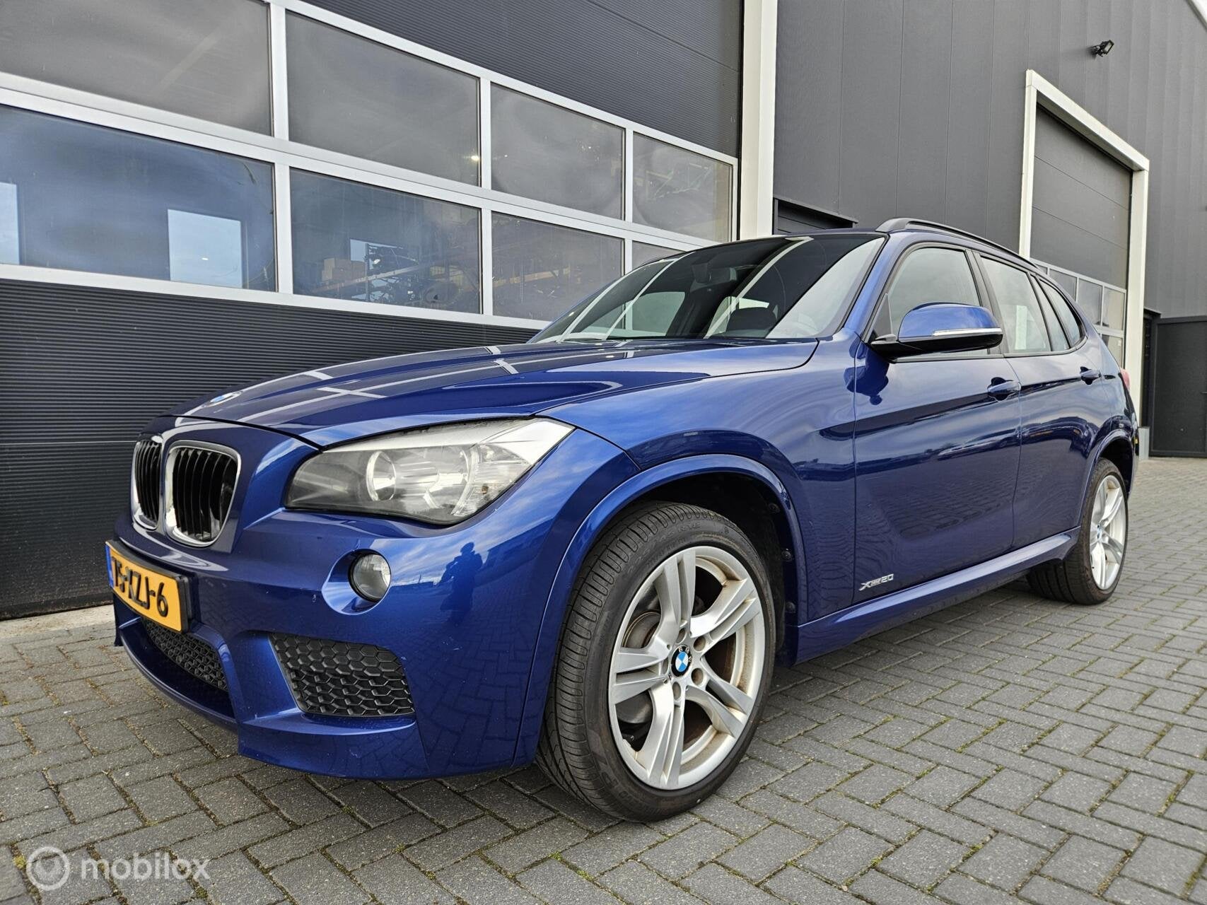 BMW X1 20i M-Pakket Le Mans Blue 184PK Nieuwe APK | Trekhaak, Auto's, Gebruikt, Zwart, 4 cilinders, 2000 kg