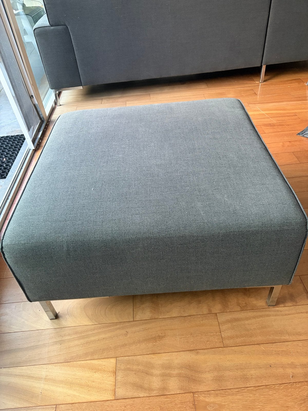 Grijze stoffen hoekbank met poef - Modern en comfortabel