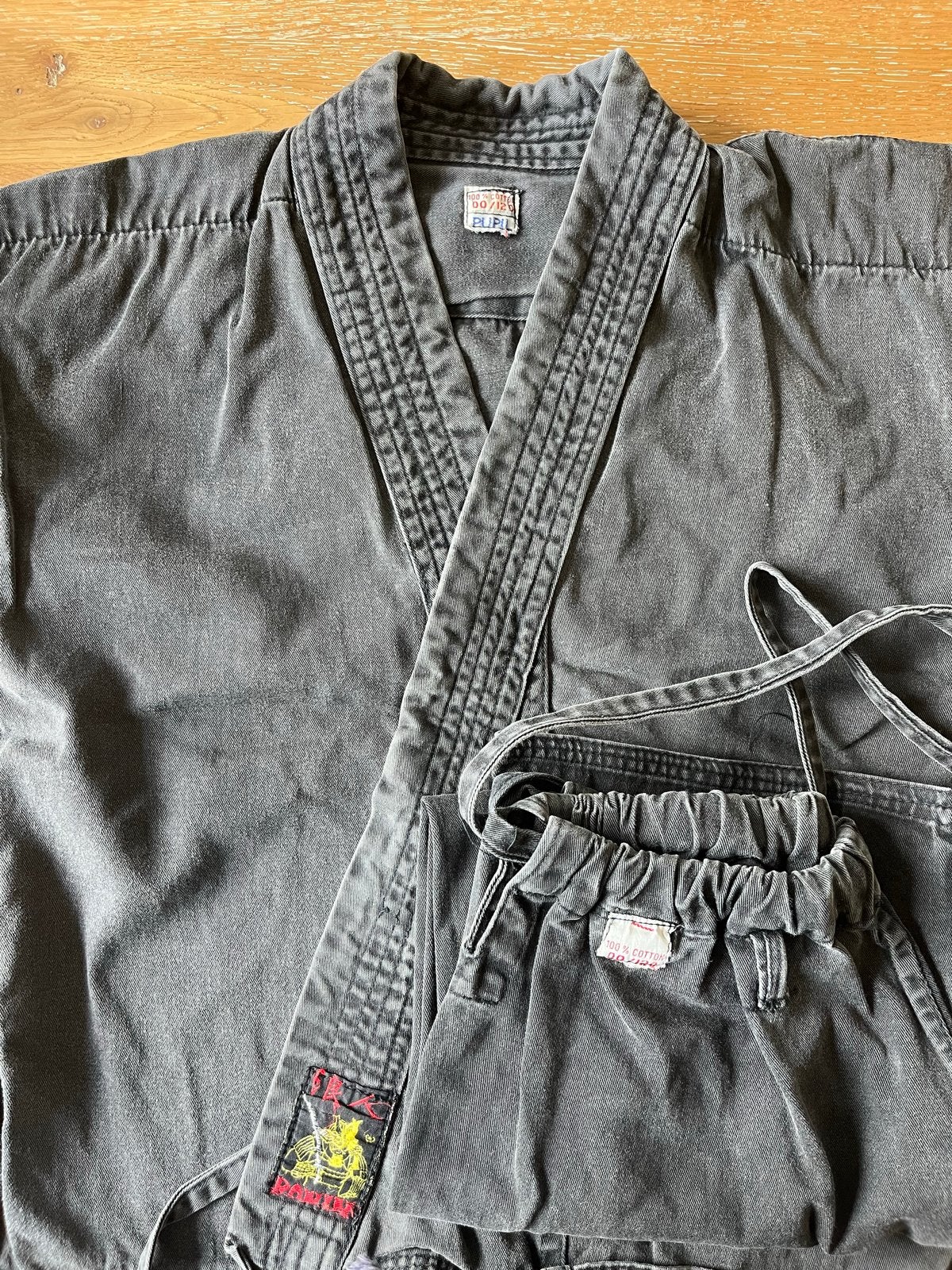 Zwart Karateka Pak Maat 120 - Verkleurd, Sport en Fitness, Vechtsporten en Zelfverdediging, Gebruikt, Maat XS of kleiner, Vechtsportpak