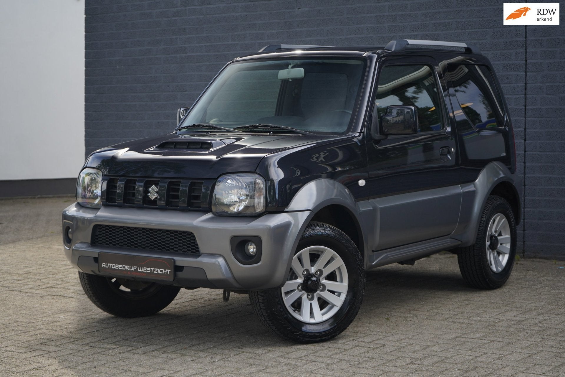 Suzuki Jimny 1.3 Exclusive 4WD, Leer, Airco, Stoelverwarming, Auto's, 86 pk, Gebruikt, Zwart, 4 stoelen