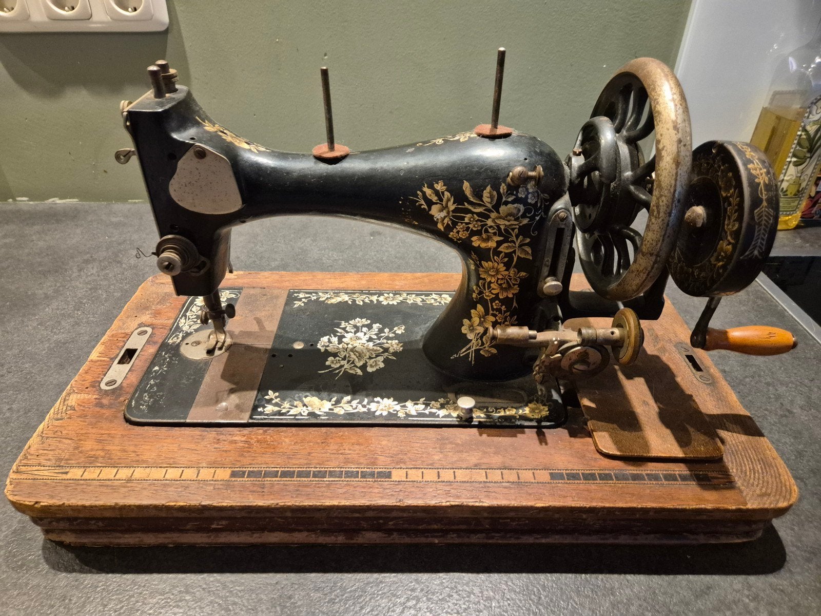 Antieke handnaaimachine met prachtige decoraties, Ophalen