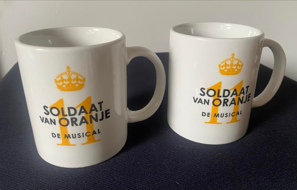 2 Mokken van Soldaat van Oranje De Musical. Hoogte 9 cm., Overige materialen, Overige typen, Ophalen of Verzenden, Zo goed als nieuw