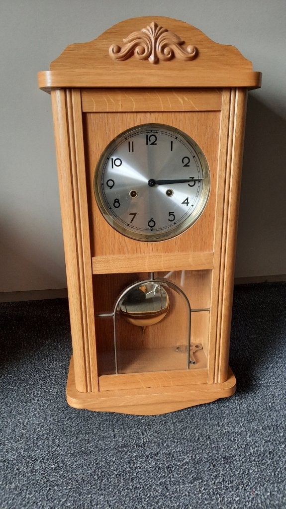 Slinger klok in houten kast met opwindsleutel., Ophalen