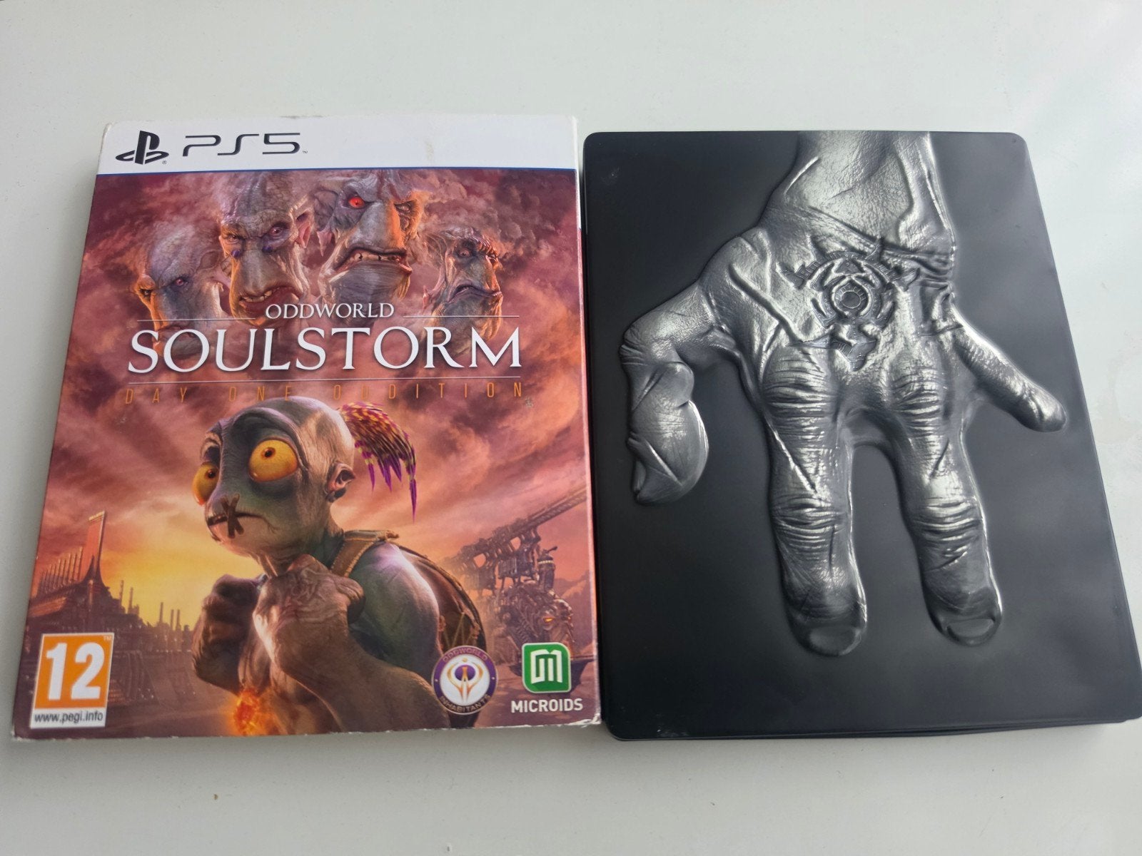 Oddworld: Soulstorm - Day One Oddition (PS5) met Metal Case, Avontuur en Actie, Info@microids.com, 57 rue Gaston Tessier - 75019 Paris - France